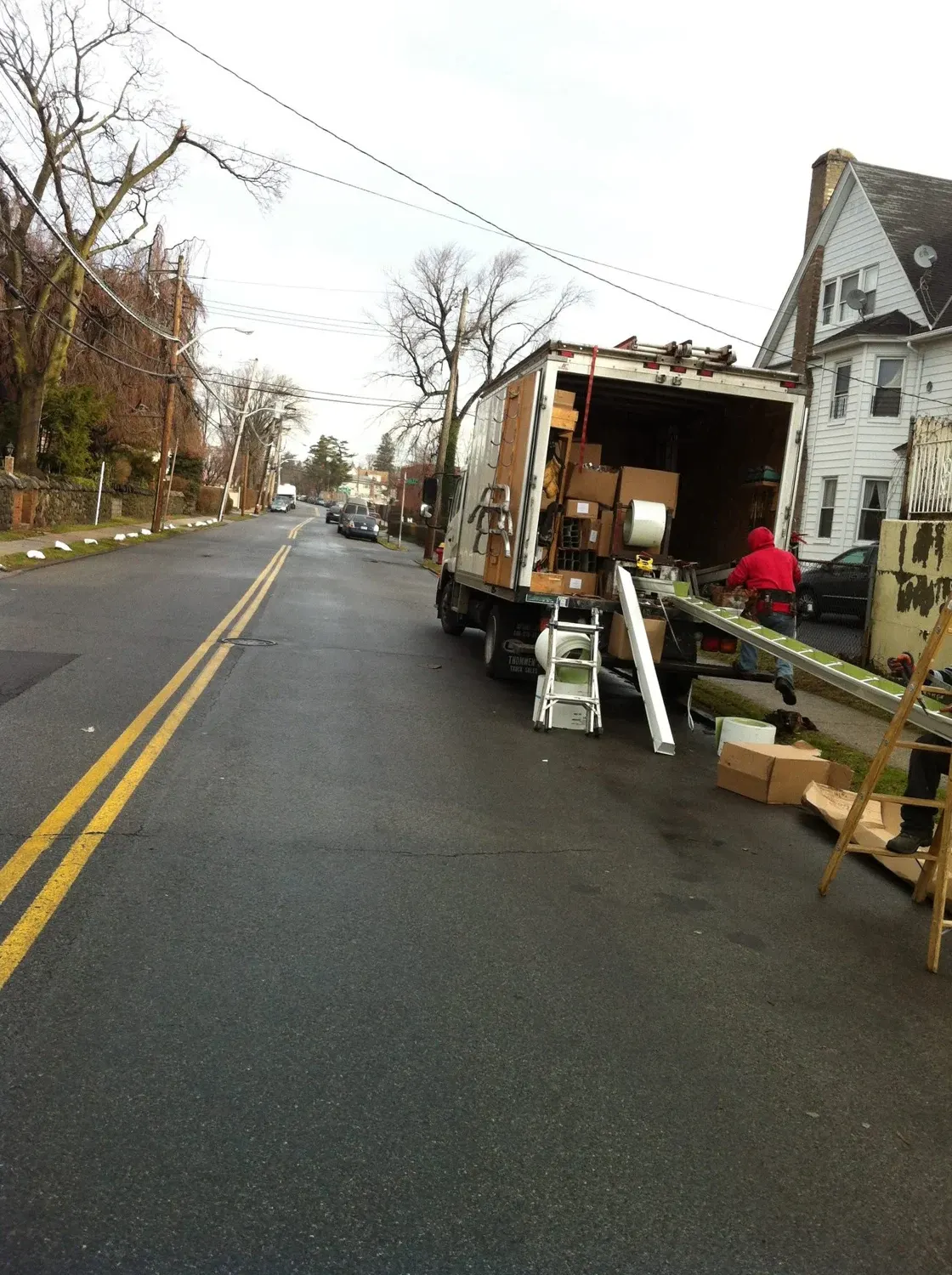 Moving truck loaded with furniture and boxes parked on residential street